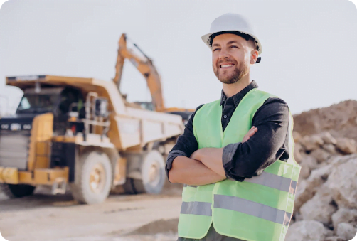 Smiling field technician standing next to a dump truck