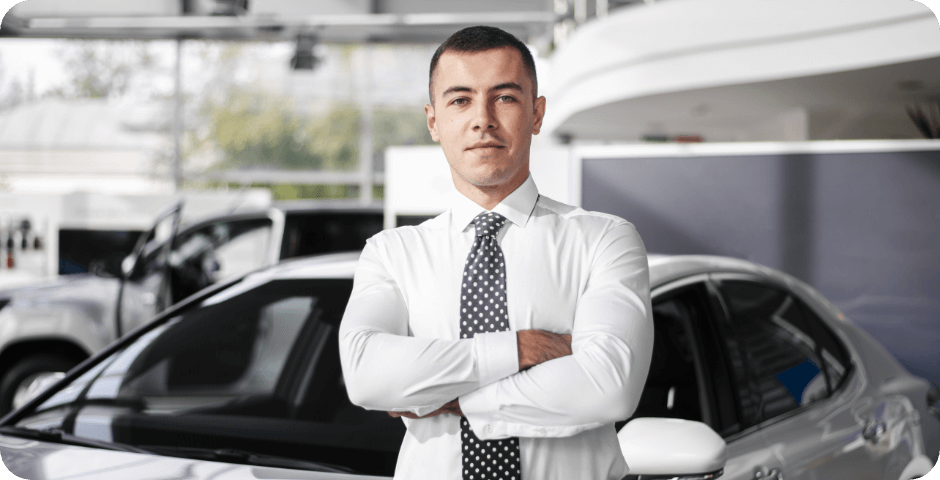 front-view-male-car-dealer-standing-with-arms-crossed