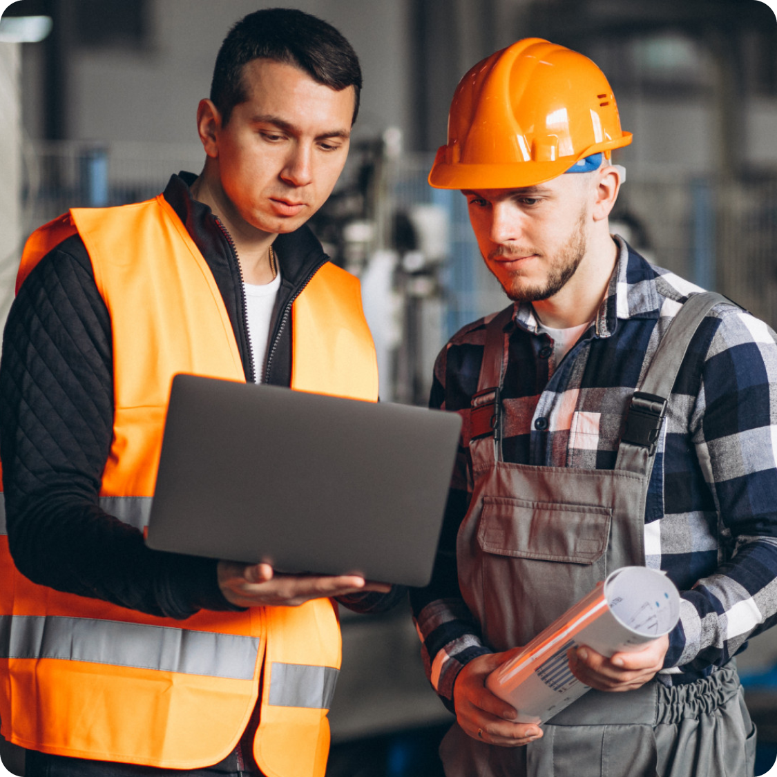 Two workers using equipment management software on a laptop for maintenance planning
