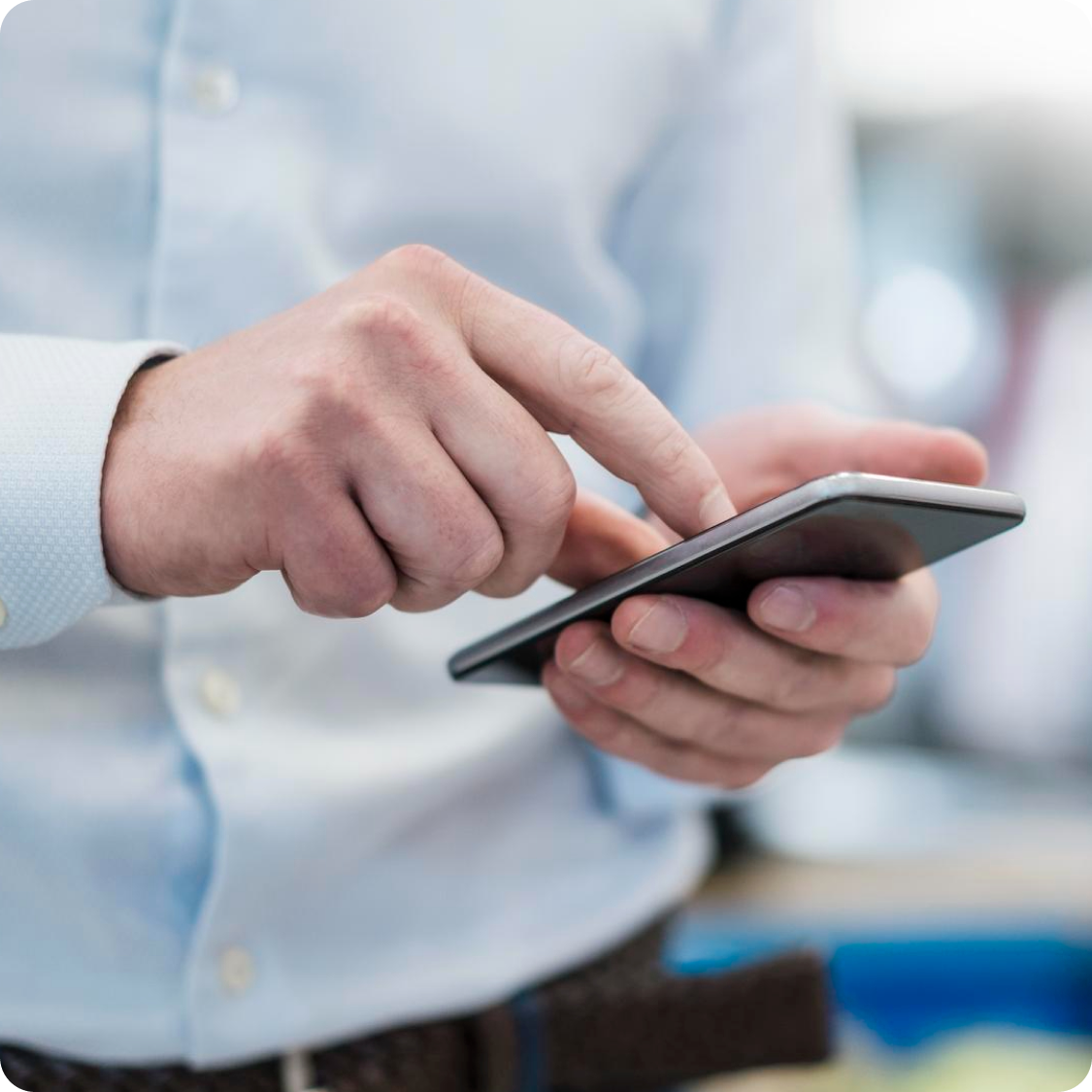 Close-up of a field manager using a smartphone to manage on-site operations and tasks through a mobile app