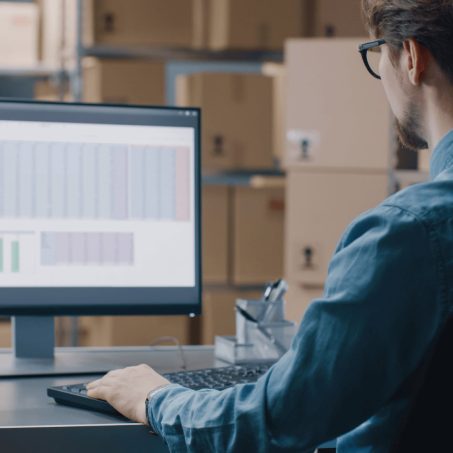 2(1) warehouse worker checking stock on a desktop computer