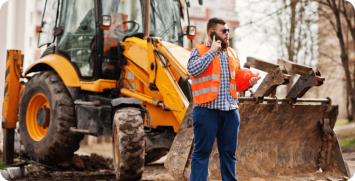 beard-worker-man-suit-construction-worker-safety-orange-helmet-sunglasses-against-tractor-with-mobile-phone-hand beard-worker-man-suit-construction-worker-safety-orange-helmet-sunglasses-against-tractor-with-mobile-phone-hand