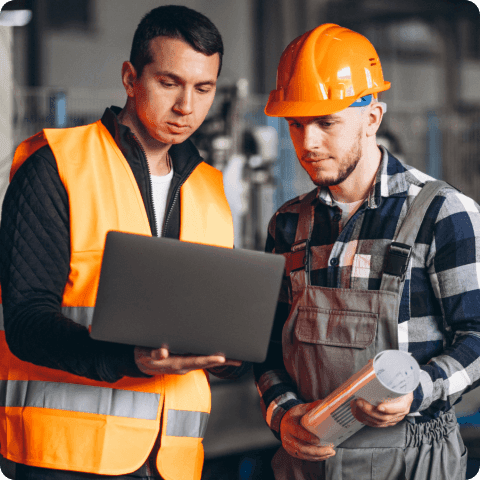 Two workers using equipment management software on a laptop for maintenance planning