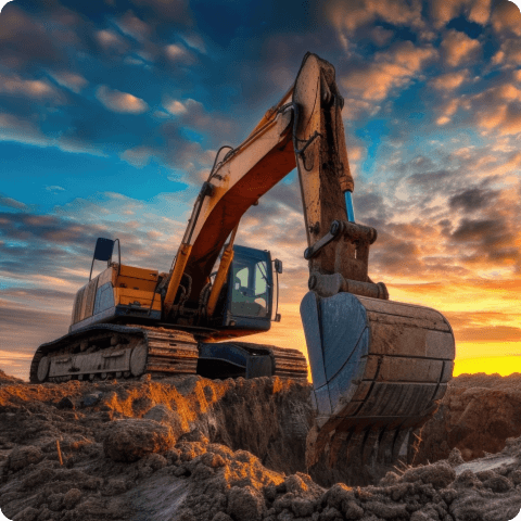 A large excavator digging at a construction site with dramatic sunset skies in the background