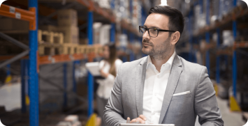 portrait-successful-businessman-manager-ceo-holding-tablet-walking-through-warehouse-storage-area-looking-towards-shelves portrait-successful-businessman-manager-ceo-holding-tablet-walking-through-warehouse-storage-area-looking-towards-shelves