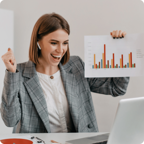 Excited Businesswoman Celebrating Sales Growth with Data Report Smiling businesswoman celebrating sales success while holding a bar chart report during a video call