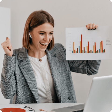 Smiling businesswoman celebrating sales success while holding a bar chart report during a video call